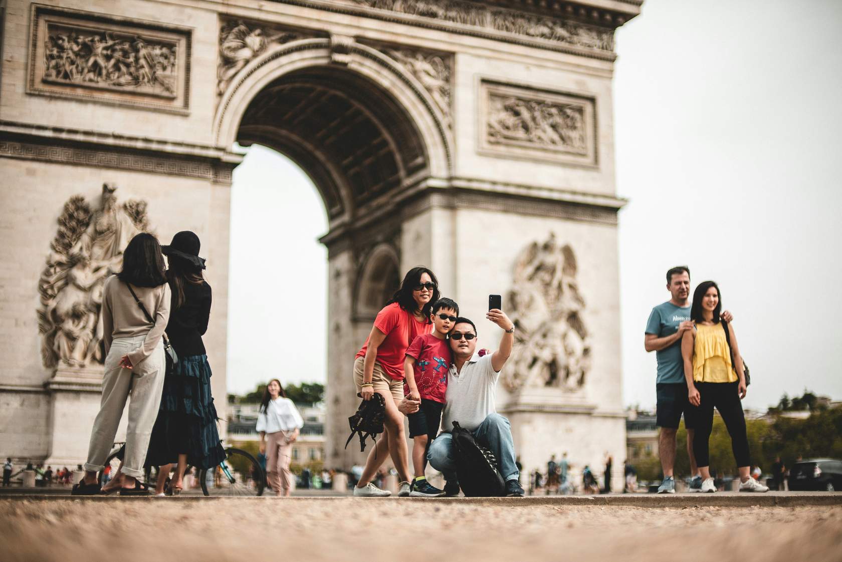 Family taking a photo at the Arc de Triomphe in Paris